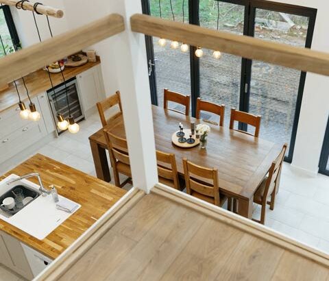 Featured image of barn conversion interior looking down from the mezzanine across an open plan kitchen diner.