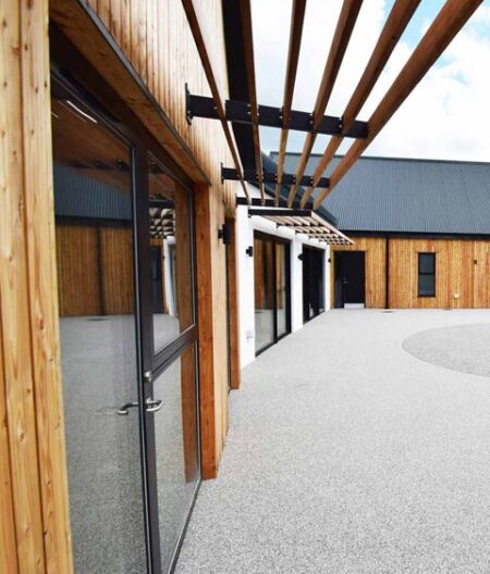 Featured image of the modern new build bungalow with full height windows overlooking accessible garden.