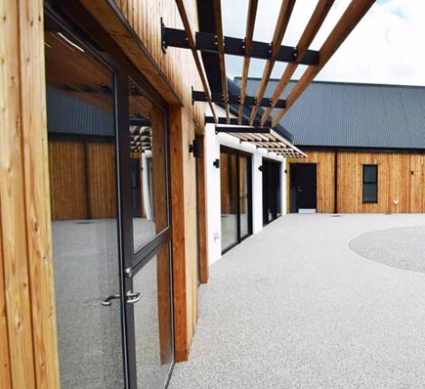 Featured image of the modern new build bungalow with full height windows overlooking accessible garden.