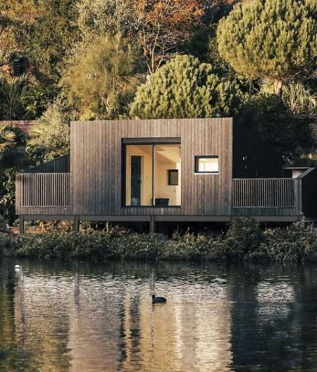 Modern lakeside modular holiday cabin with charred wood cladding.