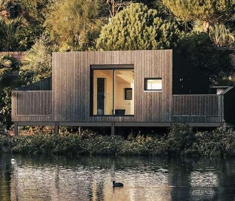 Modern lakeside modular holiday cabin with charred wood cladding.