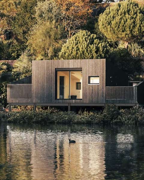 Modern lakeside modular holiday cabin with charred wood cladding.