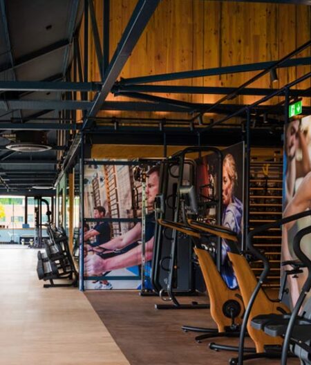 Featured image of the modern timber and steel frame workout zone with gym equipment and fitness images on the walls.