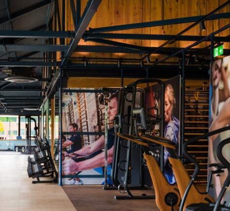 Featured image of the modern timber and steel frame workout zone with gym equipment and fitness images on the walls.