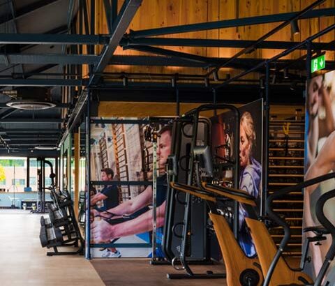 Featured image of the modern timber and steel frame workout zone with gym equipment and fitness images on the walls.