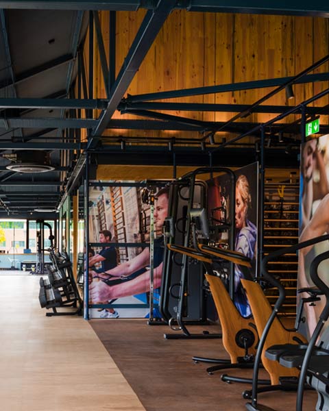 Featured image of the modern timber and steel frame workout zone with gym equipment and fitness images on the walls.
